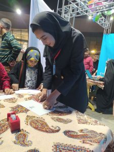 alt: اجرای آزمایش ورتکس یک و نمایش جریان هوا برای کودکان در غرفه علمی جشنواره سرزمین زندگی اصفهان